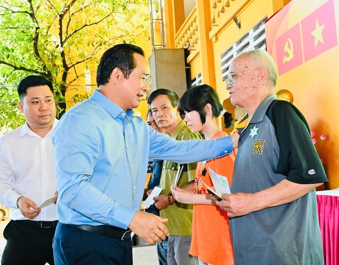 Chủ tịch UBND TPHCM trao các phần quà đến các hộ gia đình có hoàn cảnh khó khăn trên địa bàn phường nhân dịp chuẩn bị đón Tết cổ truyền của dân tộc. (Ảnh: SGGP)