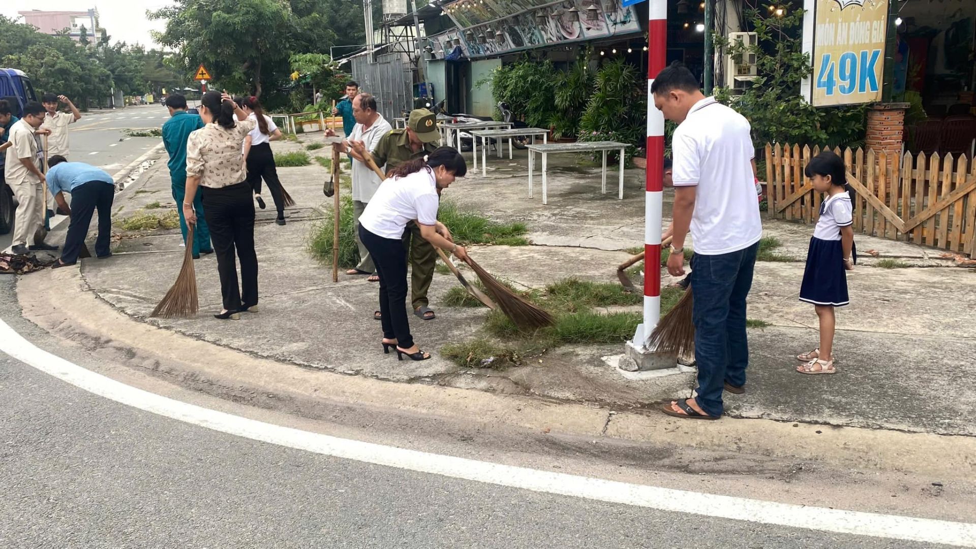 May be an image of 10 people, tree, street and text