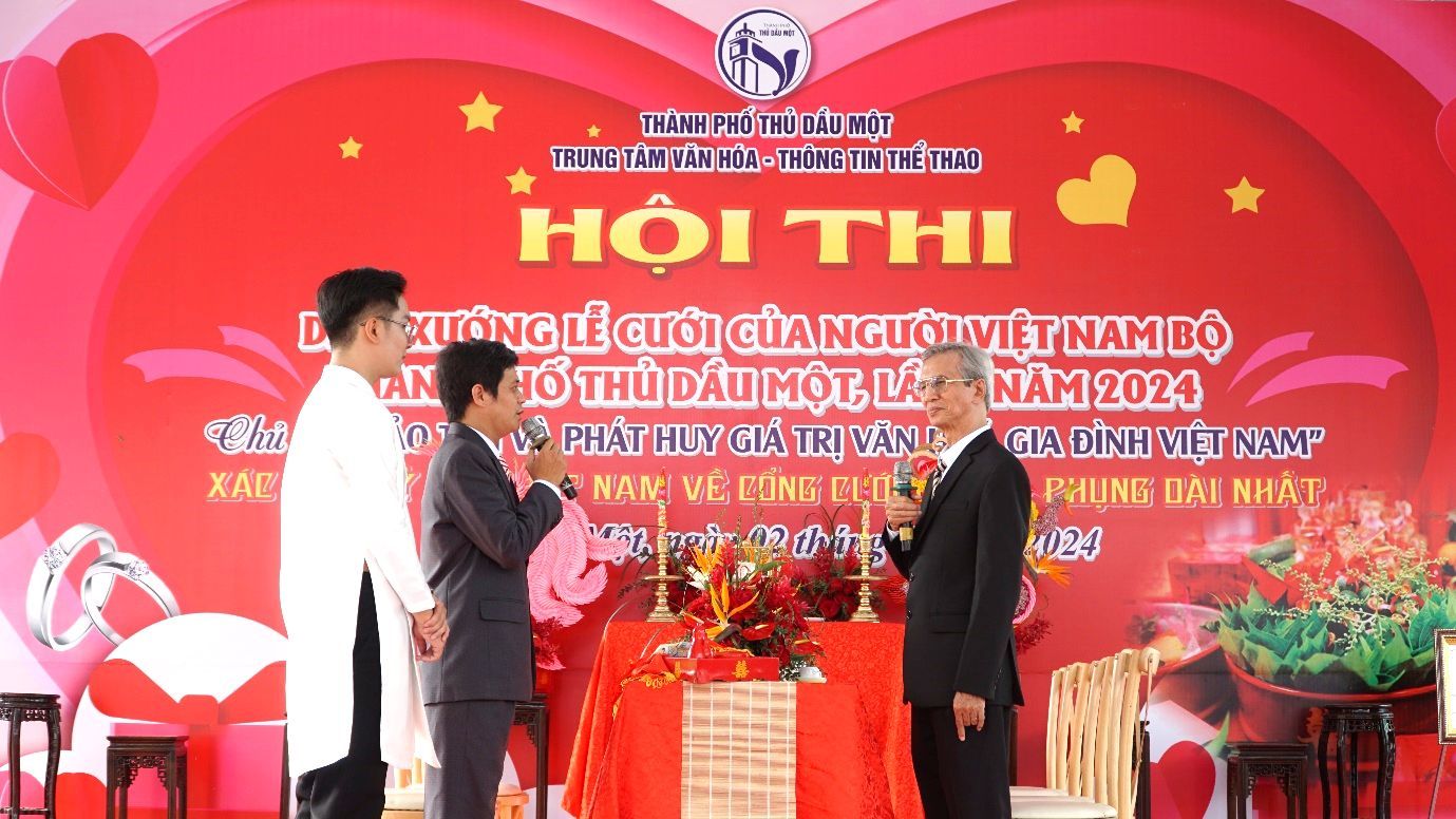 A group of men standing in front of a red bannerDescription automatically generated