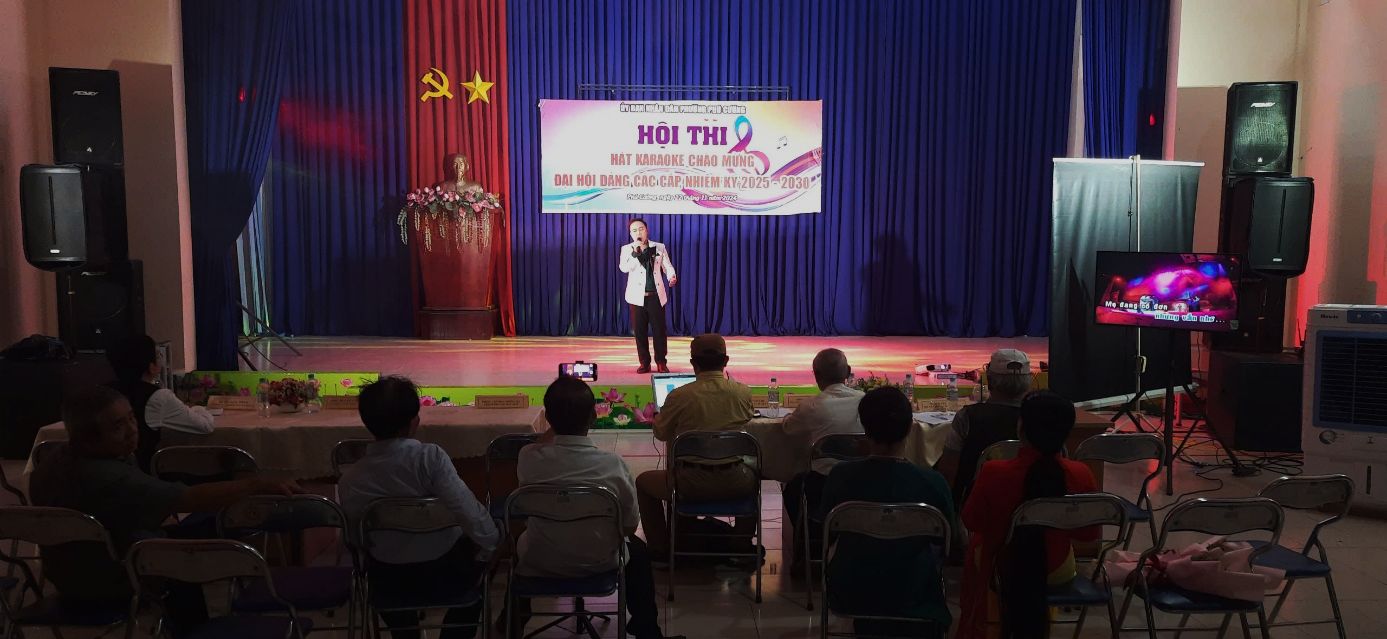 A person on stage with a microphoneDescription automatically generated