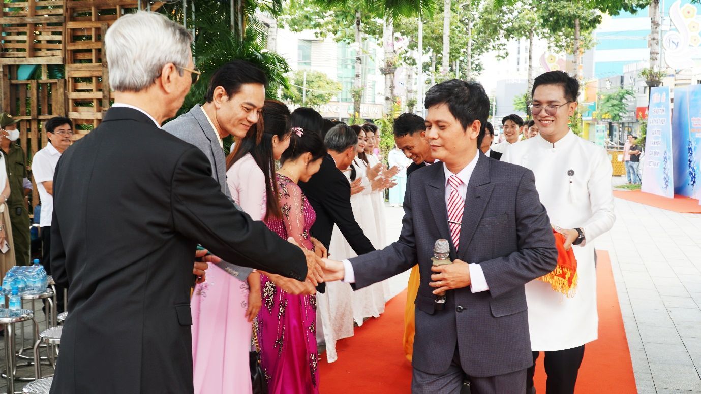 A person shaking hands with a microphoneDescription automatically generated