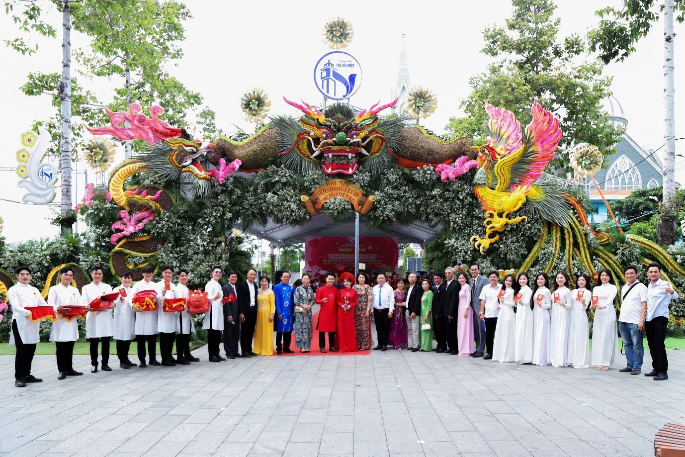 A group of people standing in front of a decorated archDescription automatically generated