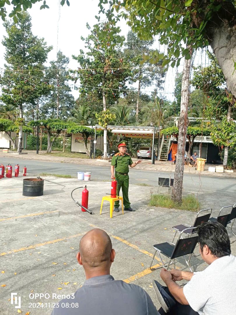 A person in a green uniform standing in a parking lotDescription automatically generated