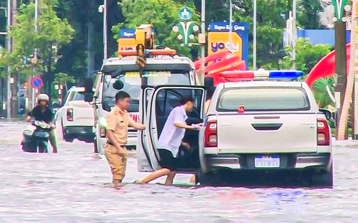 Cảnh sát giao thông lội nước ngập đón thí sinh đi thi lớp 10