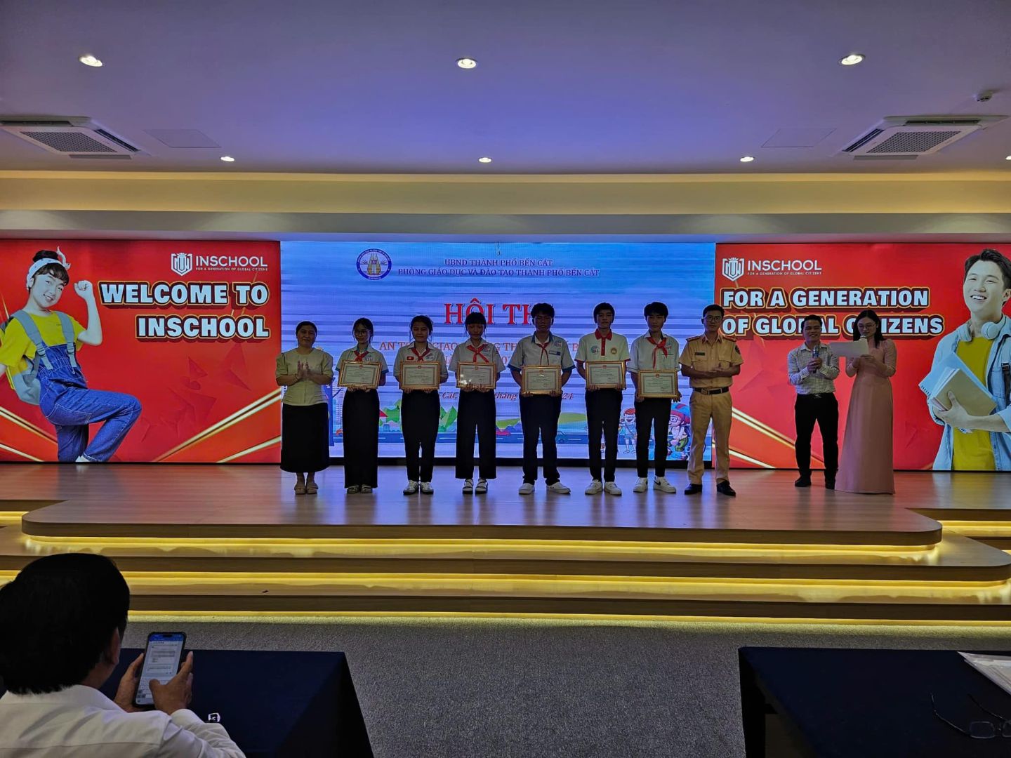 Có thể là hình ảnh về 12 người, TV, cái bục và văn bản