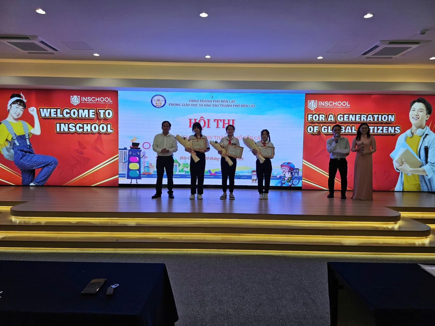 Có thể là hình ảnh về 8 người, TV, cái bục và văn bản