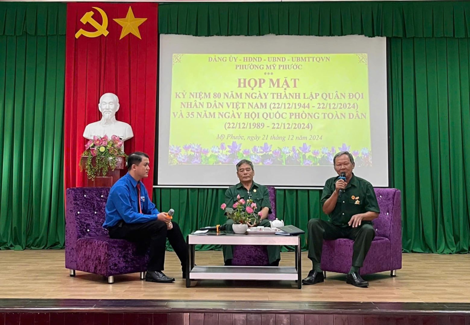 C&oacute; thể l&agrave; h&igrave;nh ảnh về 3 người, c&aacute;i bục v&agrave; văn bản cho biết '2 DANGU D&Aacute;NG.&Uuml;Y-HDND-UIND-UBMTTOWN &delta;&gamma; HDND UBND- UBMTTOVN PHƯƠNGMY MY PHƯỚC HOPMAT MẶT KY NIỆM 80 NĂM NG&Agrave;Y TH&Agrave;NH LẬP QUẢN ĐỌI NHAN DẦN VIỆT NAM (22/12/1944 22/12/2024) V&Agrave;3 VA35NĂMNG&Agrave;Y 35 NĂM NG&Agrave;Y HỘI QUỐC PH&Ograve;NG TO&Agrave;N D&Acirc;N (22/12/1989- (22/12/1989-22/12/2024) 22/12/2024) MP Phuic, ngay th&aacute;ng 12 năm 2024'