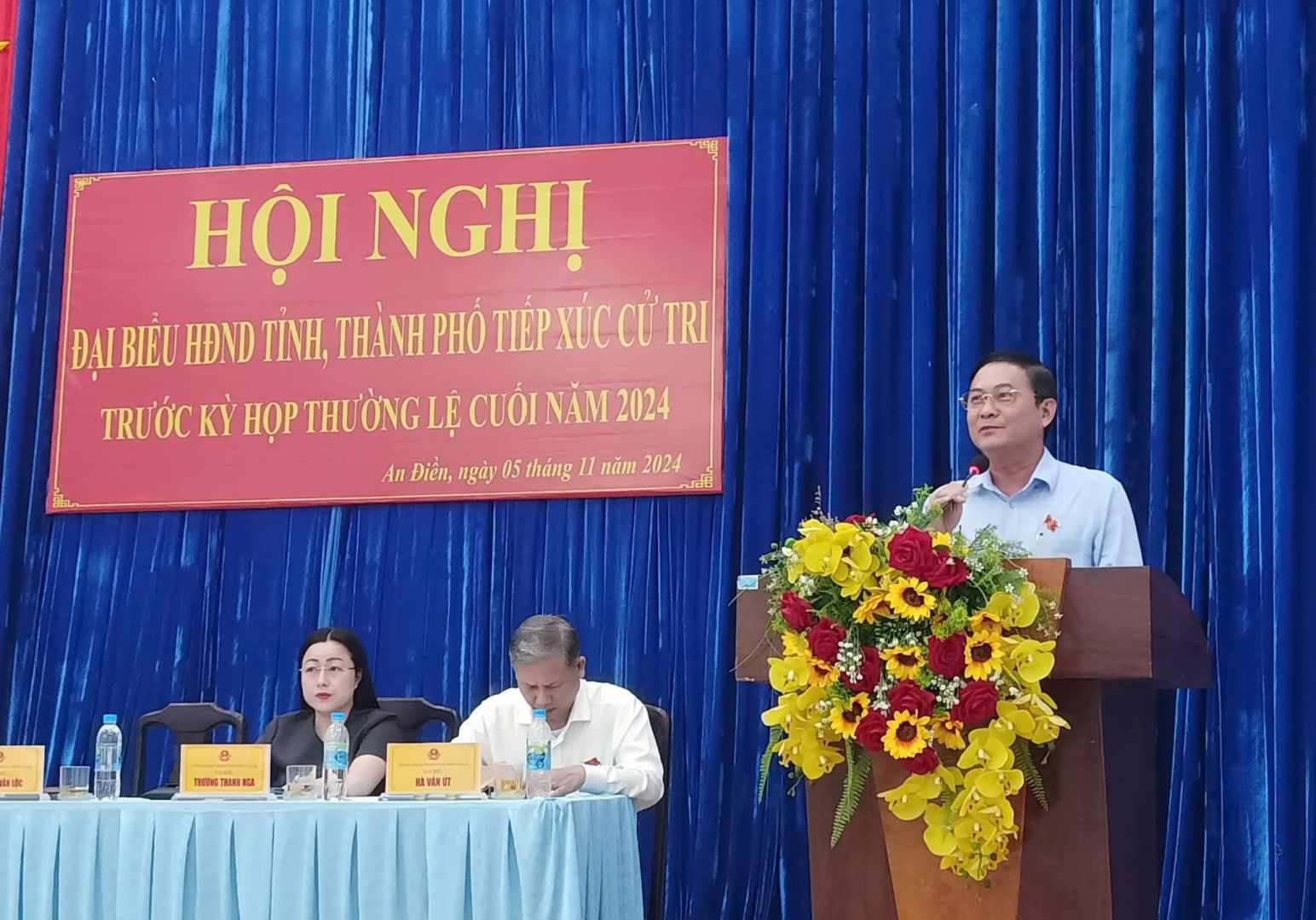 Có thể là hình ảnh về 3 người, cái bục và văn bản
