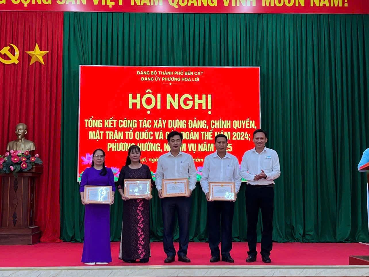 Có thể là hình ảnh về 5 người, cái bục và văn bản cho biết 'ou 一 NNIVe uOHa VIIL HOON NHI: Q ĐANG BO THANH PHO BEN CAT ĐÀNG DANG PHƯƠNG HOA OI HỘI NGHỊ TỔNG KẾT CÔNG TÁC XÂY DỰNG ĐÁNG, CHÍNH QUYÉN, MẶT TRÂN TÔ QUỐC VA JOÀN HE اقتر 2024: PHƯƠN HƯỞNG, N M VỤ NAM 5 nâm 민, nga'