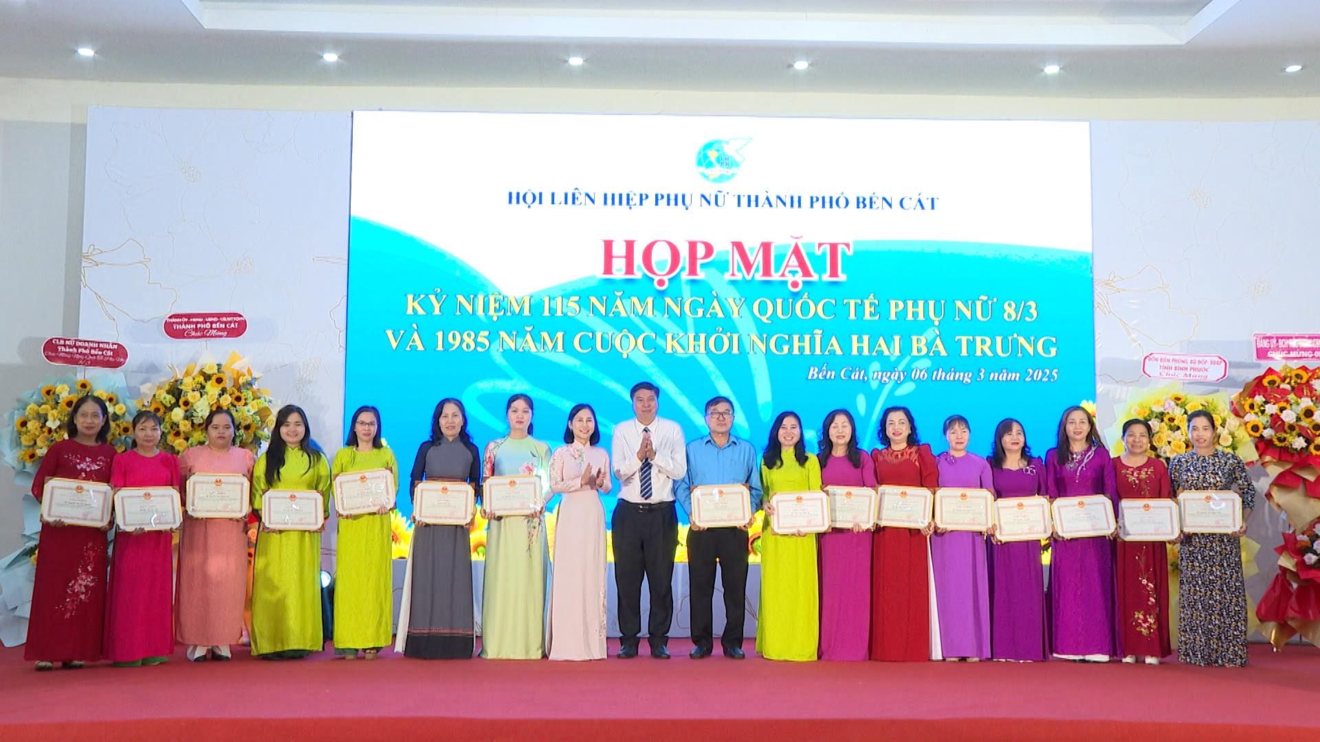 Có thể là hình ảnh về 16 người, cái bục và văn bản cho biết 'HIỌI IÊN HIỆP தவ்சையகக் NỮ THÀNHI ΡΙό BÉNCAT BÊN HỌP HỌPMẠT MẠT KỲ NIỆM 115 NĂM NGÀY QUOC QU TẾ PHỤ NỮ 8/3 VÀ1985 NĂM CUỘC ΚHσΊ NGHĨA HAI BA TRƯNG VÀ 1985 NĂMCUỘC BénCát, αAά 06 thàng กนักา hea.Cal.angorthingndm2028 ndm2025 2025'