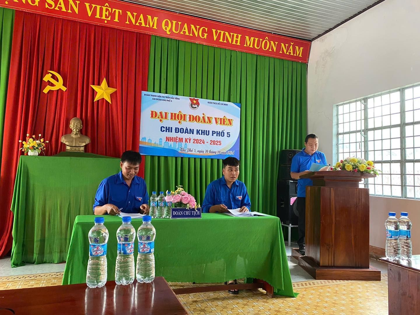 Có thể là hình ảnh về 3 người, cái bục và văn bản